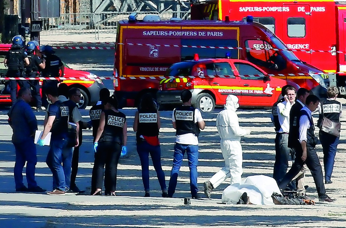 Criminal police inspect the body of a suspect at the scene of an incident in which a car rammed a gendarmerie van on the Champs-Elysees Avenue in Paris, France, June 19, 2017. Reuters/Gonzalo Fuentes