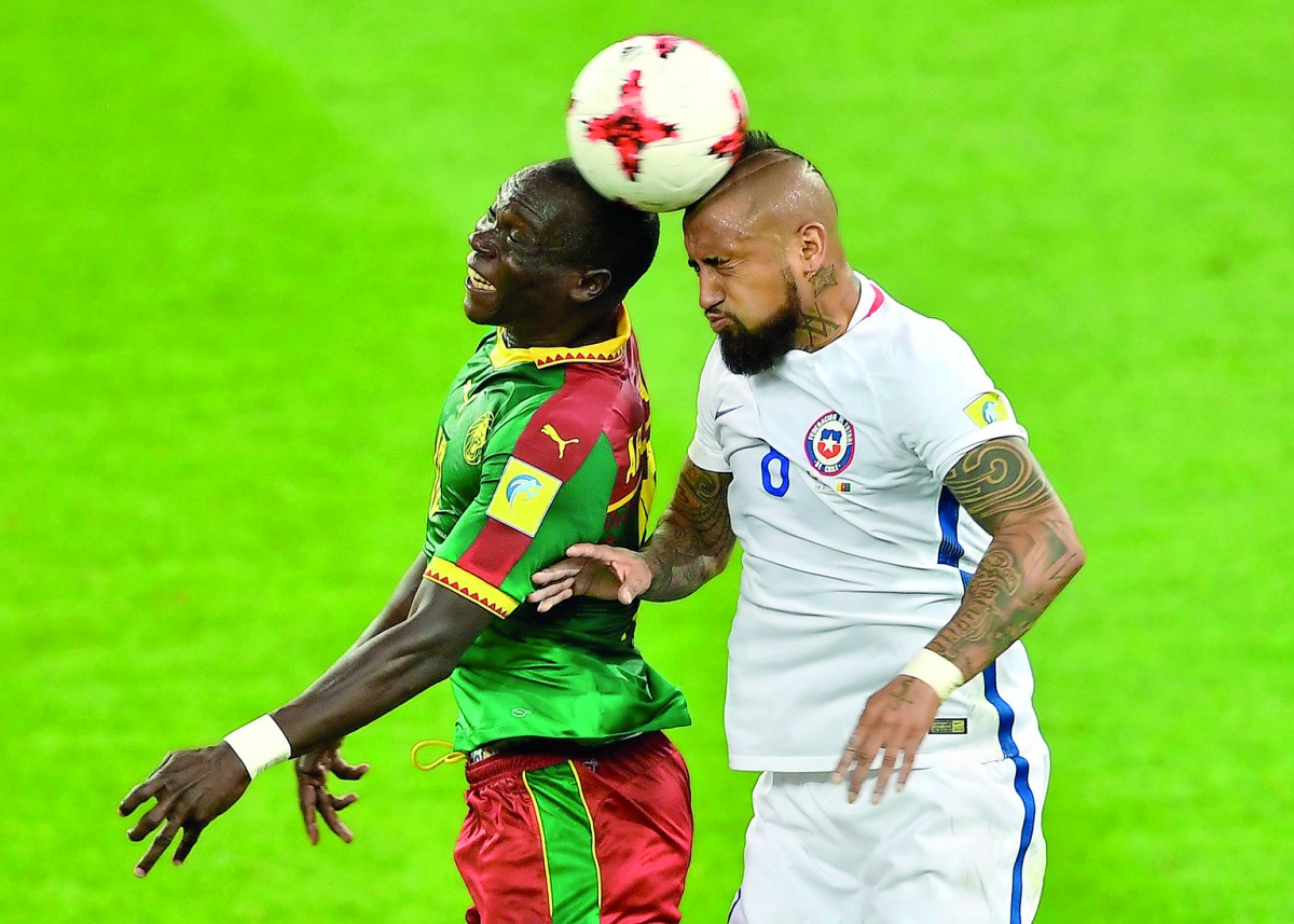 Cameroon's forward Vincent Aboubakar (left) heads the ball with Chile's midfielder Arturo Vidal during the 2017 Confederations Cup group B match at the Spartak Stadium in Moscow on Saturday.