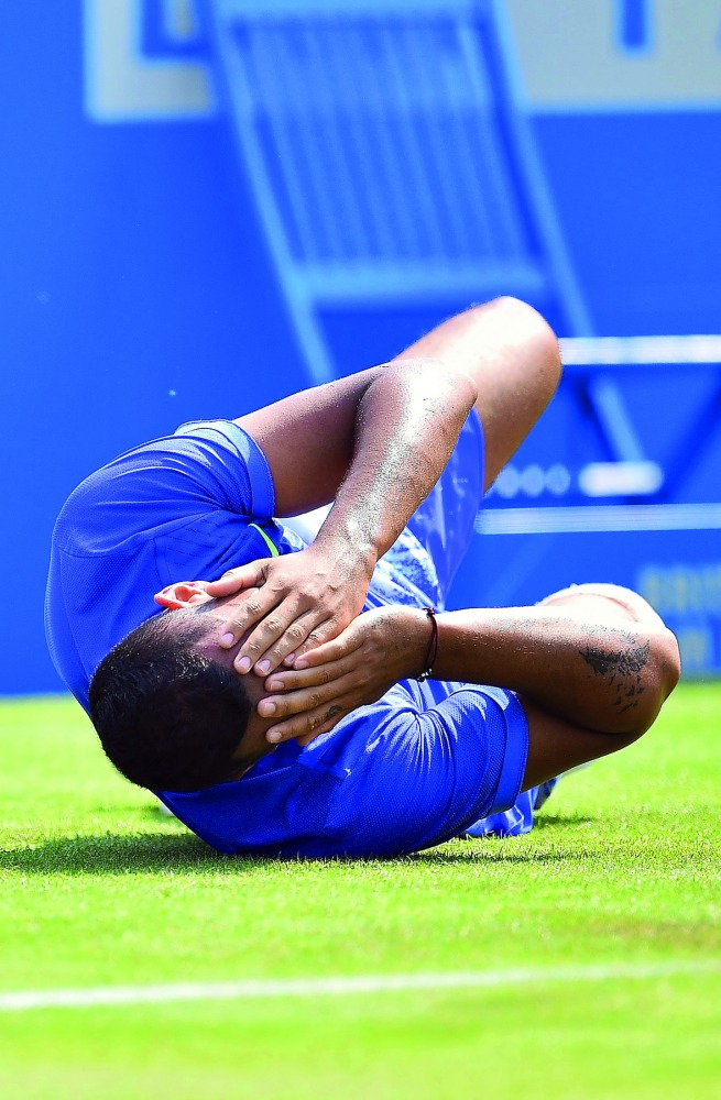 Australia's Nick Kyrgios reacts after slipping during his men's singles 1st round match against Donald Young of the US at the ATP Aegon Championships tennis tournament at Queen's Club in London, yesterday. 