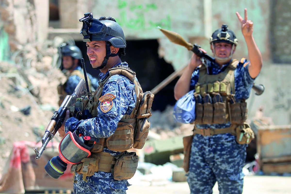 An Iraqi forces member raises the victory sign as he holds a rocket-propelled grenade during the advance towards the Old City of Mosul , yesterday.
