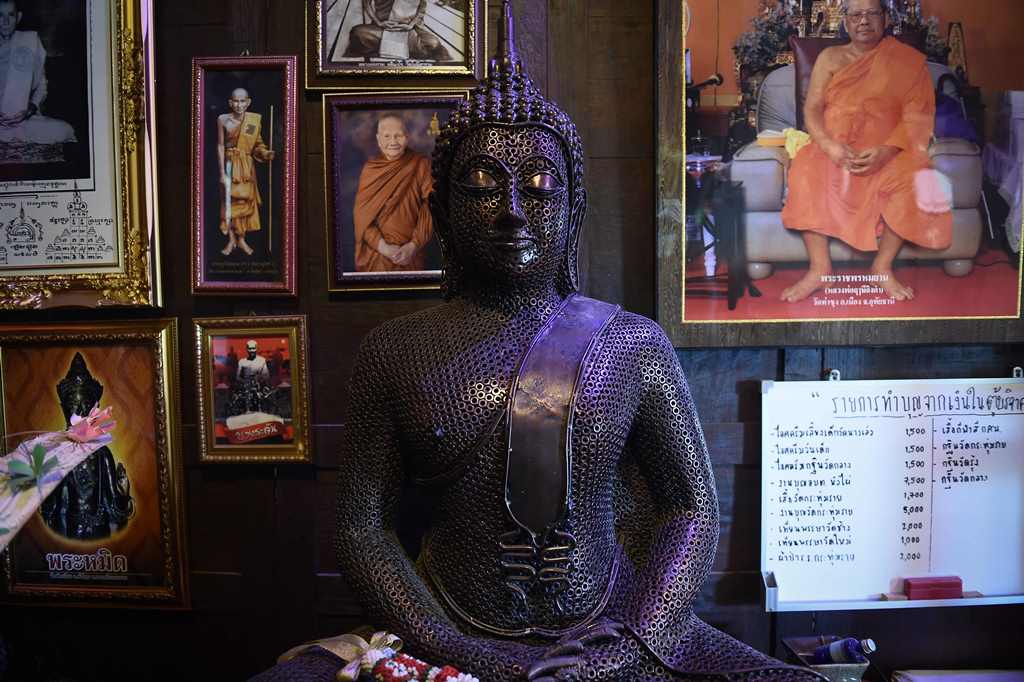 This photo taken on June 13, 2017 shows a Buddha wrought from recycled metal at Ban Hun Lek, a metal works shop renowned for giant statues of Transformers, the Hulk and other pop icons, in the central Thai province of Angthong. AFP / LILLIAN SUWANRUMPHA