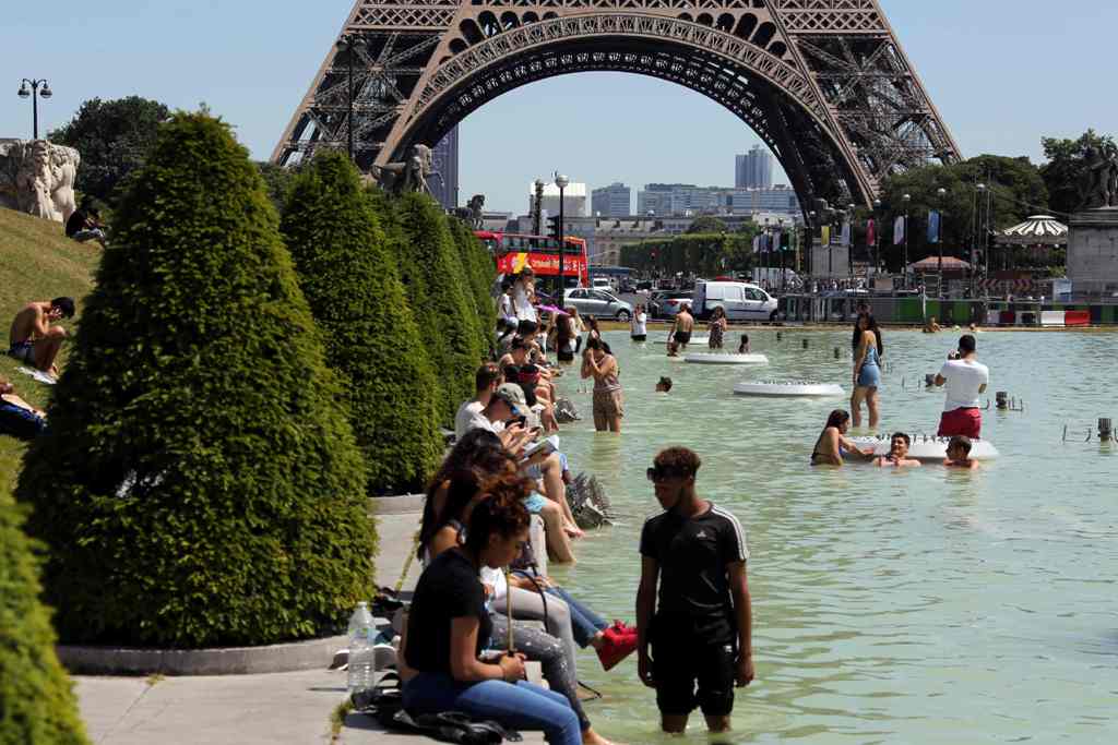 People refresh themselves in the Trocadero fountain in Paris, on June 19, 2017, as the French capital is placed on heatwave alert as temperatures are set to soar in the coming days. / AFP / LUDOVIC MARIN
