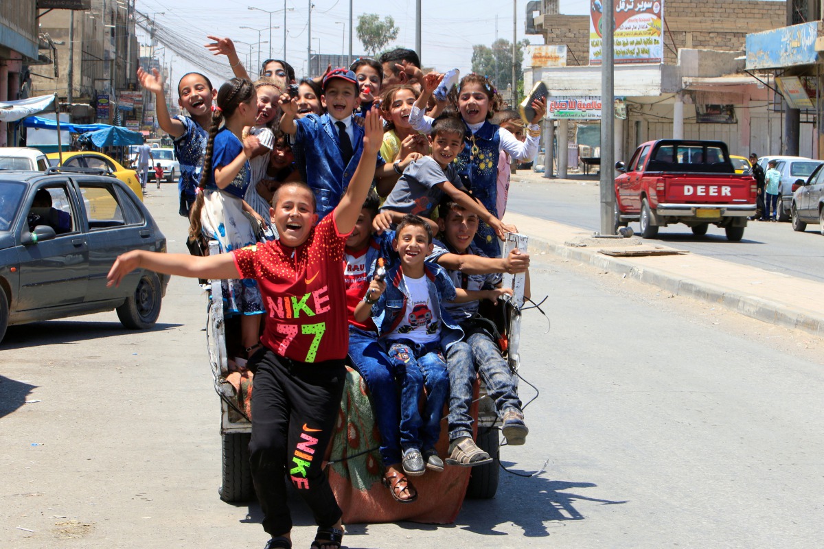 Iraqi children enjoy riding a mini car as they celebrate Eid al-Fitr, in Mosul, Iraq June 25, 2017. (REUTERS/Alaa Al-Marjani)