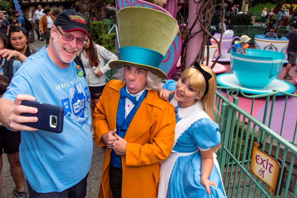 This photo courtesy of Disney shows Huntington Beach, California, resident Jeff Reitz snaps a selfie with The Mad Hatter and Alice after a teacup ride at the Mad Tea Party in Fantasyland at Disneyland on June 22, 2017, during his 2,000th visit to the park