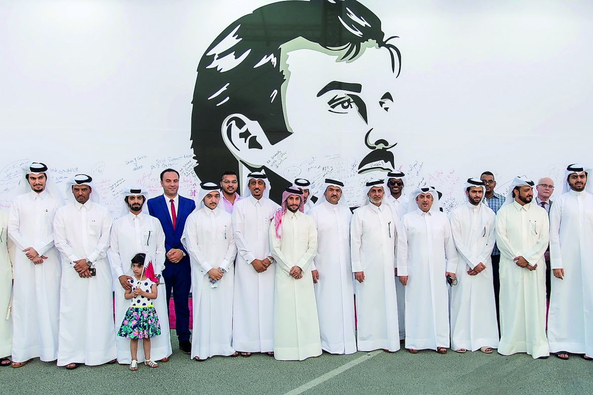 Officials and other well-wishers at the UDC's installation of Tamim Al Majd mural in The Pearl-Qatar. UDC Chairman Turki bin Mohammed Al Khater (left) signing the mural.  Pic: Abdul Basit / The Peninsula