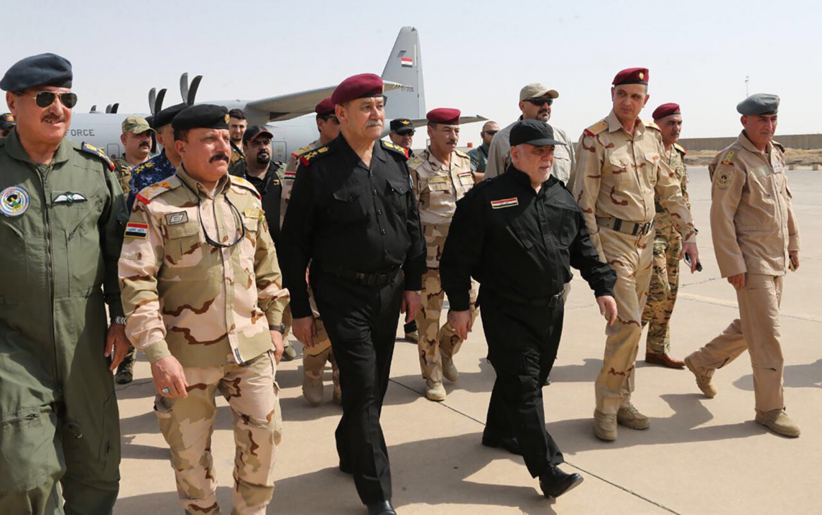 A handout picture released by the Iraqi prime minister's press office on July 9, 2017, shows Iraqi Prime Minister Haider al-Abadi (3rd from R) walking alongside police and army officers upon his arrival in Mosul. ( AFP / IRAQI PRIME MINISTER'S PRESS OFFIC