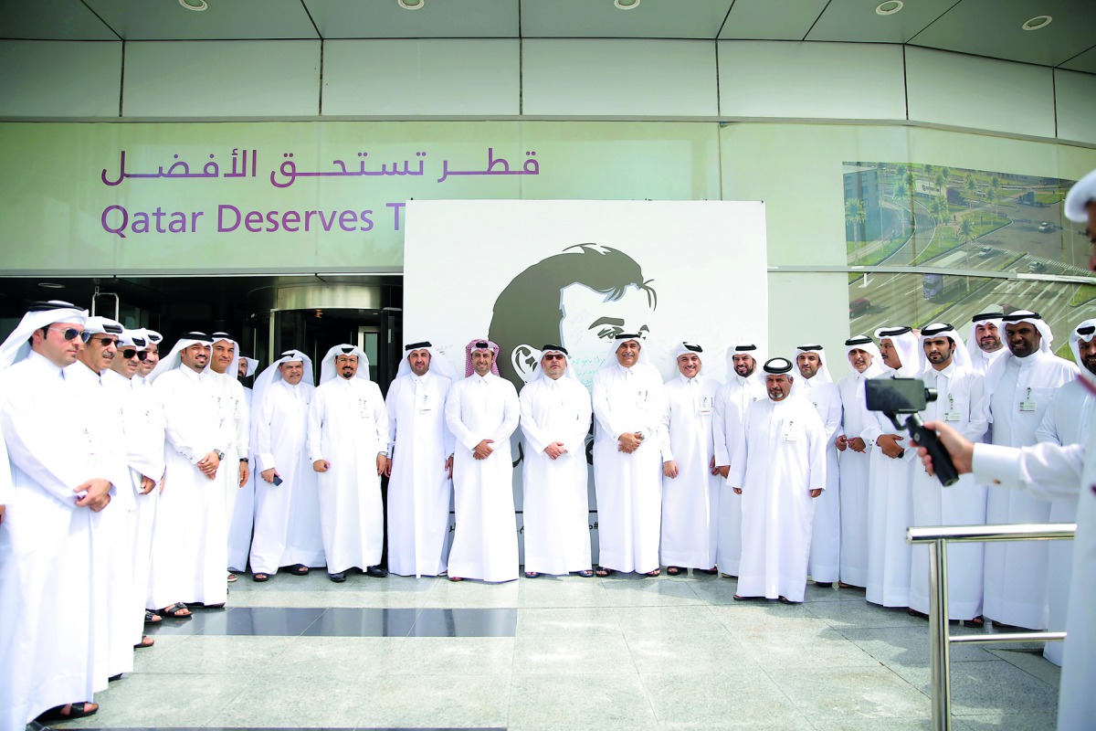 Officials of Ashghal with the mural of Emir H H Sheikh Tamim bin Hamad Al Thani in front of its office in Doha.