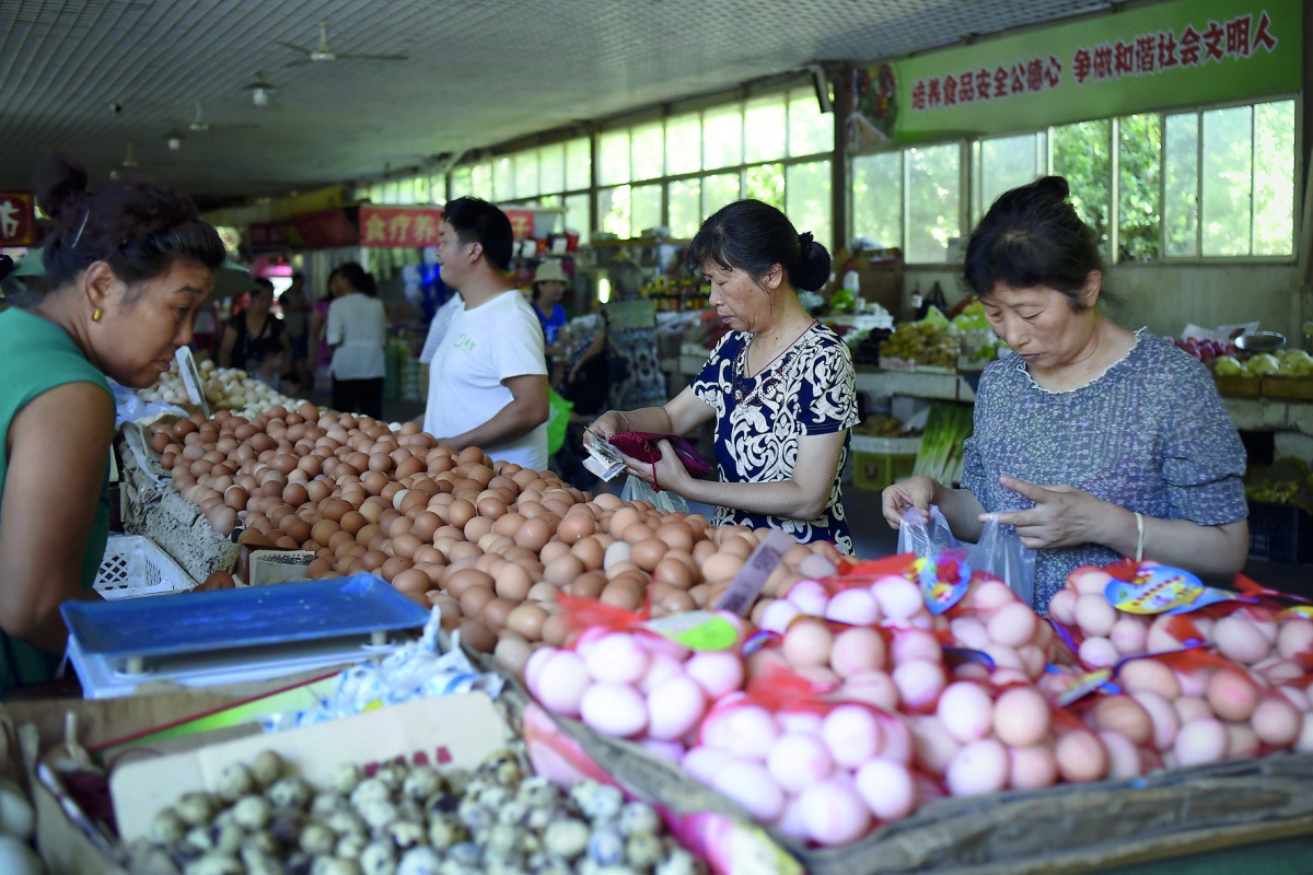 People shop for eggs at a market in Beijing. China's factory gate prices stabilised in June after slowing for three straight months.