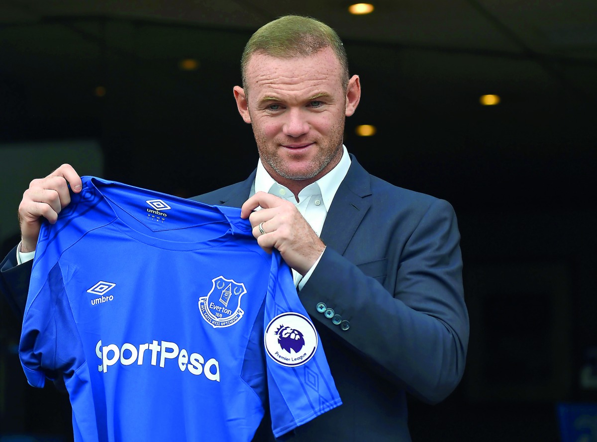 Everton's new signing, English striker Wayne Rooney poses for a photograph with his club shirt following a press conference at Goodison Park in Liverpool yesterday.