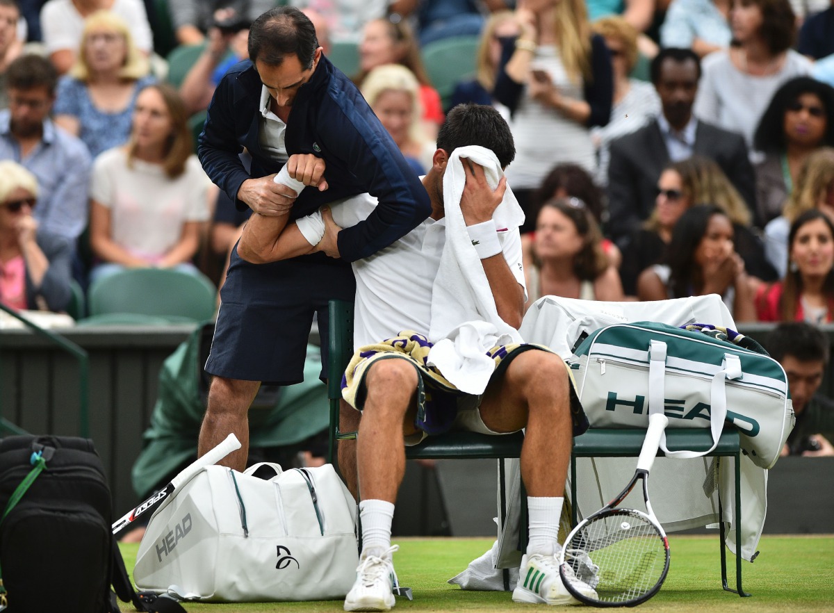 Serbia's Novak Djokovic gets some medical attention on court in a break between games against France's Adrian Mannarino during their men's singles fourth round match on the eighth day of the 2017 Wimbledon Championships at The All England Lawn Tennis Club