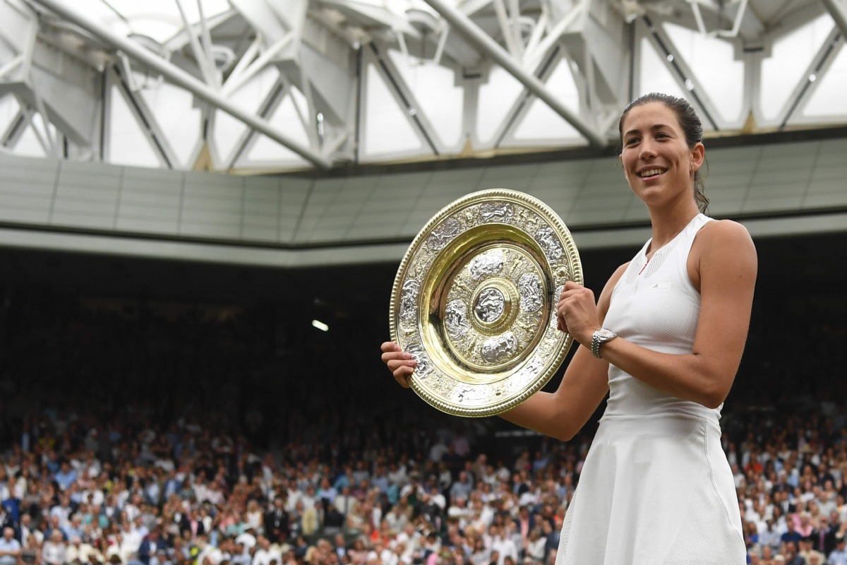 Spain's Garbine Muguruza holds up The Venus Rosewater Dish as she celebrates beating US player Venus Williams to win the women's singles final on the twelfth day of the 2017 Wimbledon Championships at The All England Lawn Tennis Club in Wimbledon, southwe