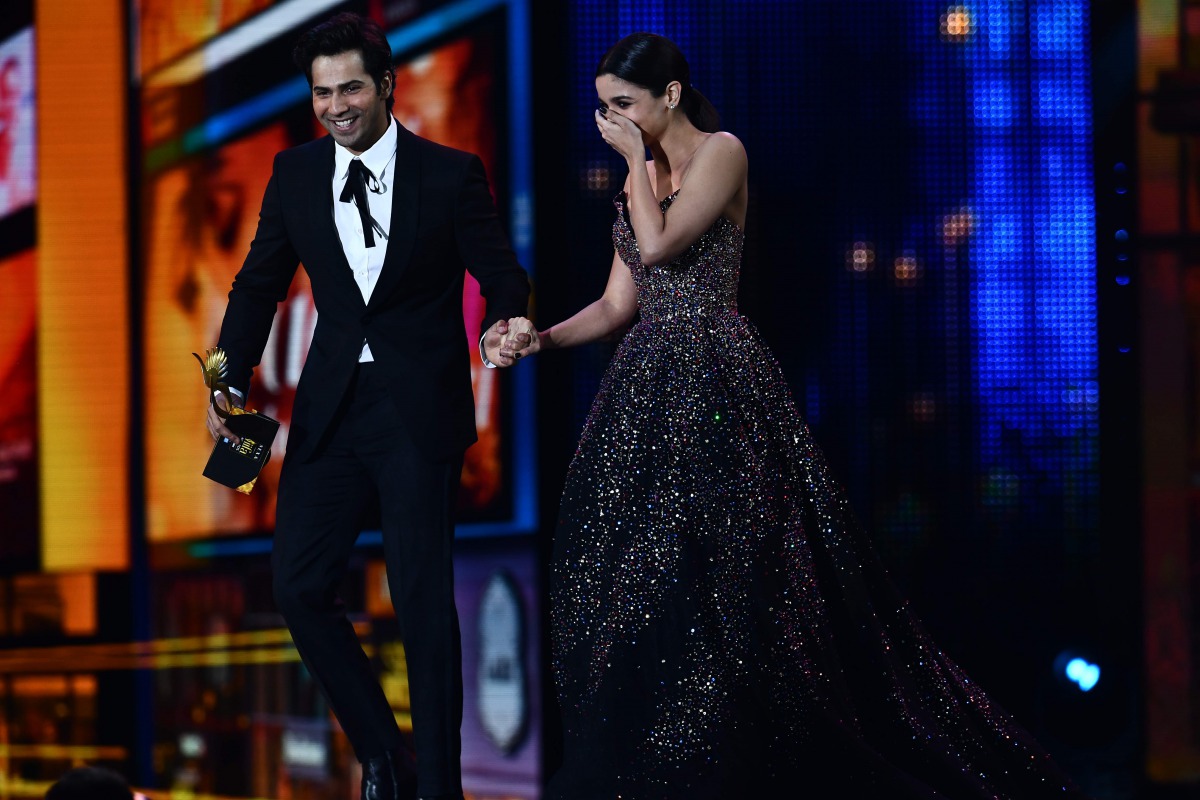 Alia Bhatt reacts after learning she got the award for Best Actress as she arrives with Varun Dhawan on stage during the IIFA Awards July 15, 2017 at the MetLife Stadium in East Rutherford, New Jersey during the 18th International Indian Film Academy (IIF