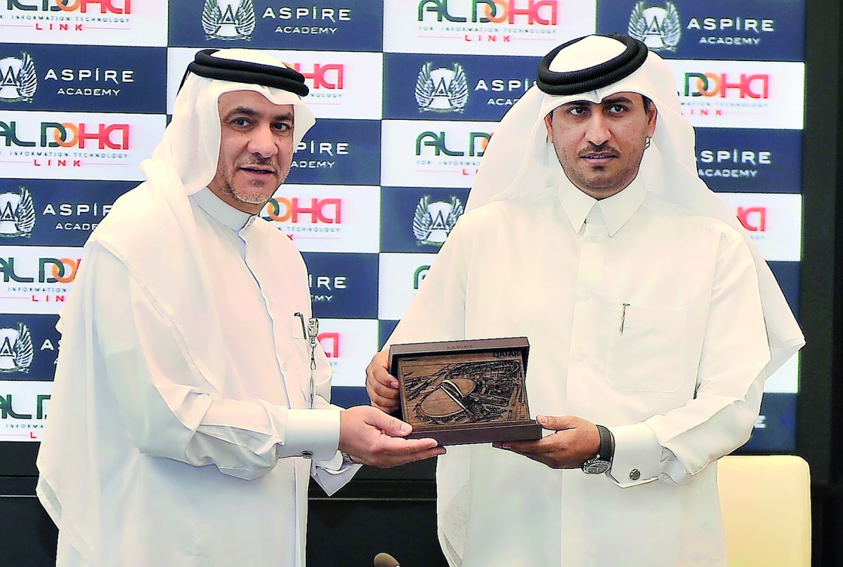 Bader Al Hay, Director of Education and Student Affairs of Aspire Academy, presents a gift to Hamad bin Rashid Al Naimi, Chairman of ALDOHA Link for IT during the signing ceremony at Aspire Academy yesterday. Pic: Baher Amin/ The Peninsula