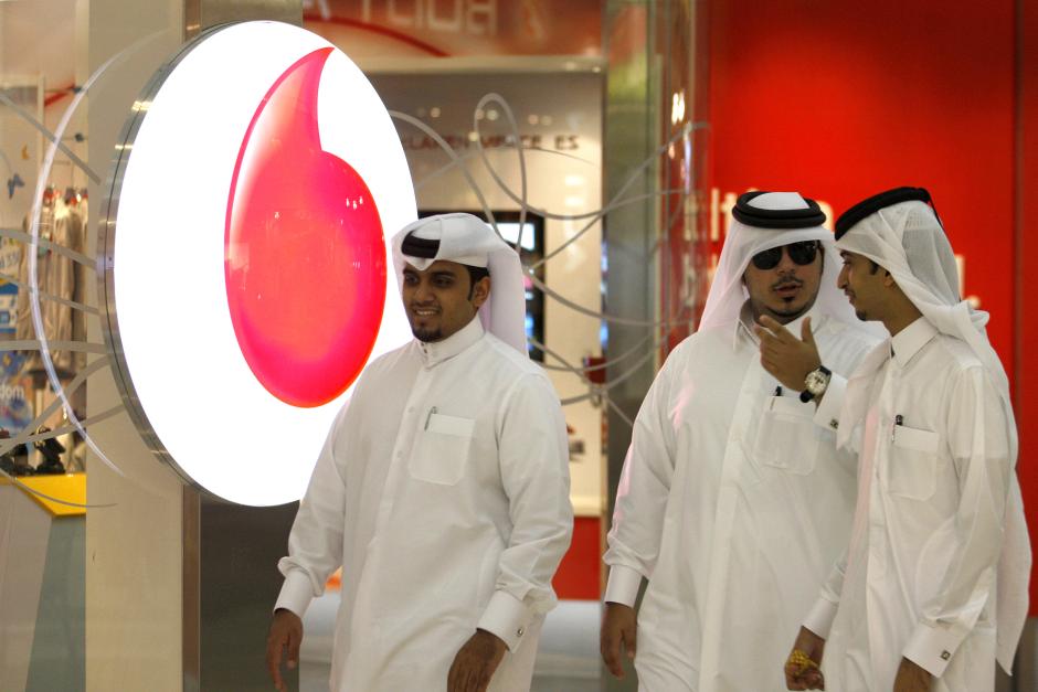 Men walk past a Vodafone-Qatar Telecommunication office in Doha, October 22, 2009 (Reuters / Fadi Al-Assaad)