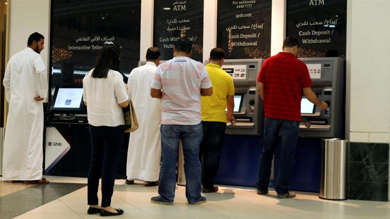 People removing cash from ATMs in Qatar (Reuters)