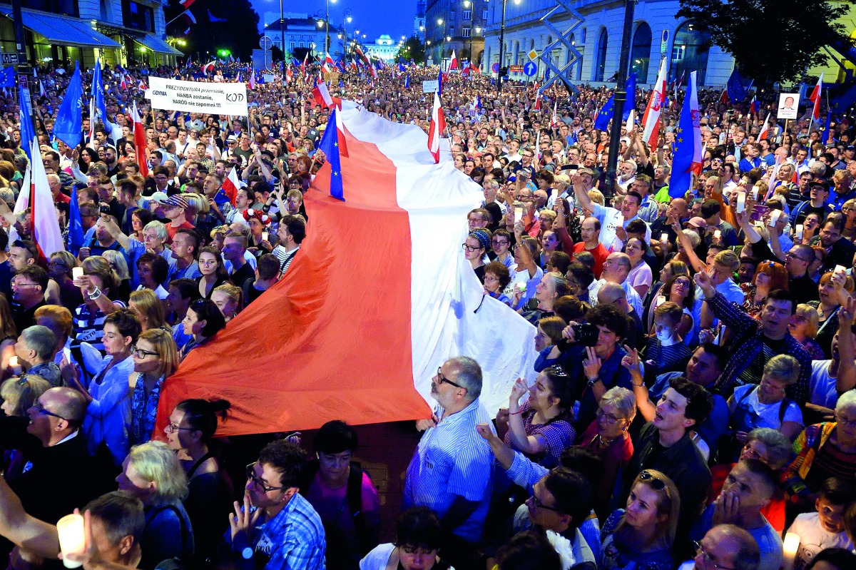 People raise candles and hold a Polish flag  during a protest in front of the Presidential Palace, in Warsaw, yesterday.