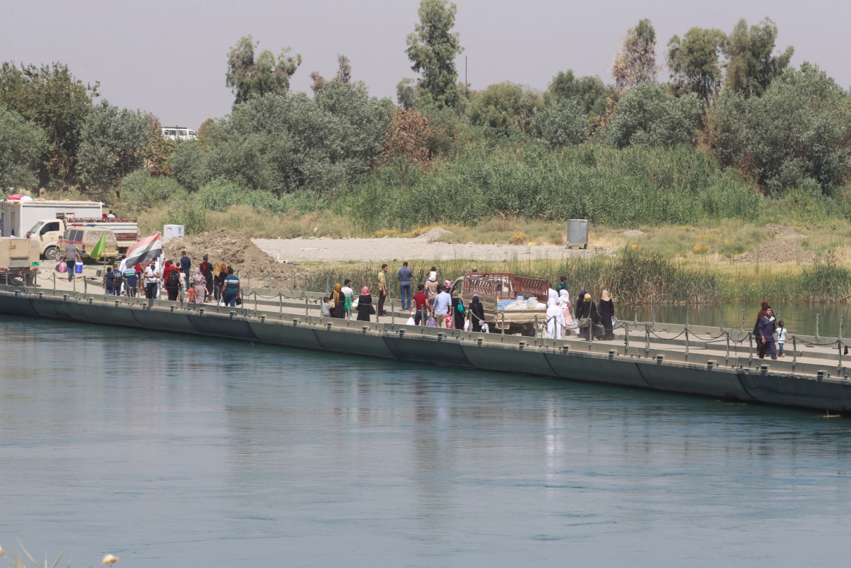 Iraqis walk towards the floating bridge between east and west of Mosul, Iraq, July 21, 2017. Picture taken July 21, 2017. (REUTERS/Khalid Al-Mousily)