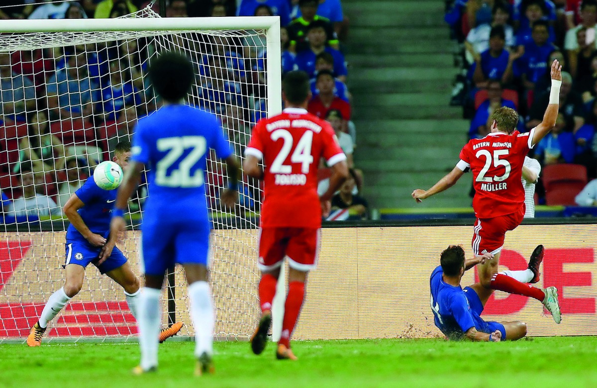 Bayern Munich’s Thomas Mueller (right) scores during their International Champions Cup match against Chelsea, played at the National Stadium in Singapore yesterday.