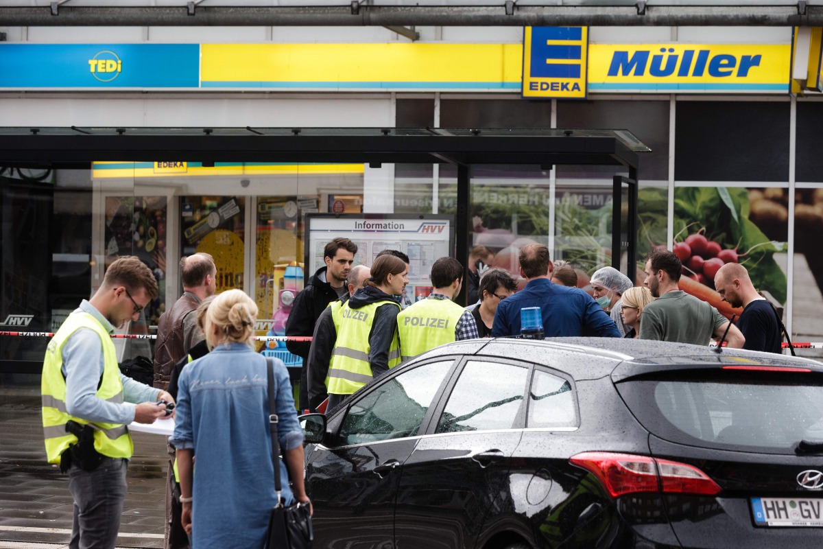Police investigator work at the area around a supermarket in the northern German city of Hamburg, where a man killed one person and wounded several others in a knife attack, on July 28, 2017. (AFP / dpa / Markus Scholz)