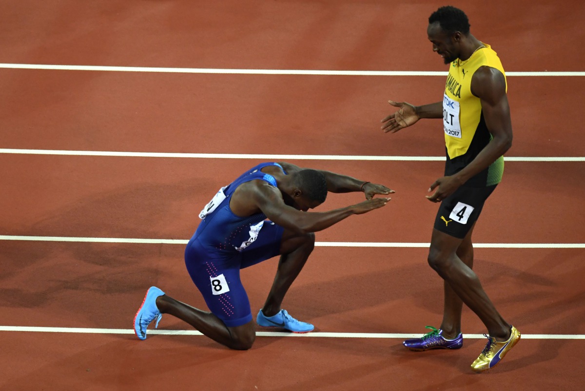 US athlete Justin Gatlin kneels in front of Jamaica's Usain Bolt after Gatlin won the final of the men's 100m athletics event at the 2017 IAAF World Championships at the London Stadium in London on August 5, 2017. (AFP / ANTONIN THUILLIER)