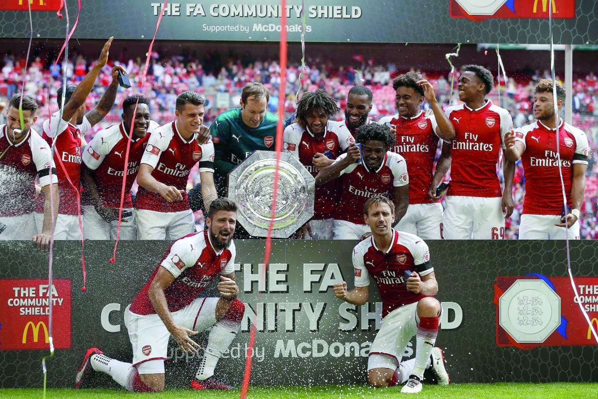Arsenal players hold the Shield as they celebrate victory after the English FA Community Shield match against Chelsea at Wembley Stadium in London, yesterday.  Arsenal won 4-1 on penalties after the game ended 1-1.