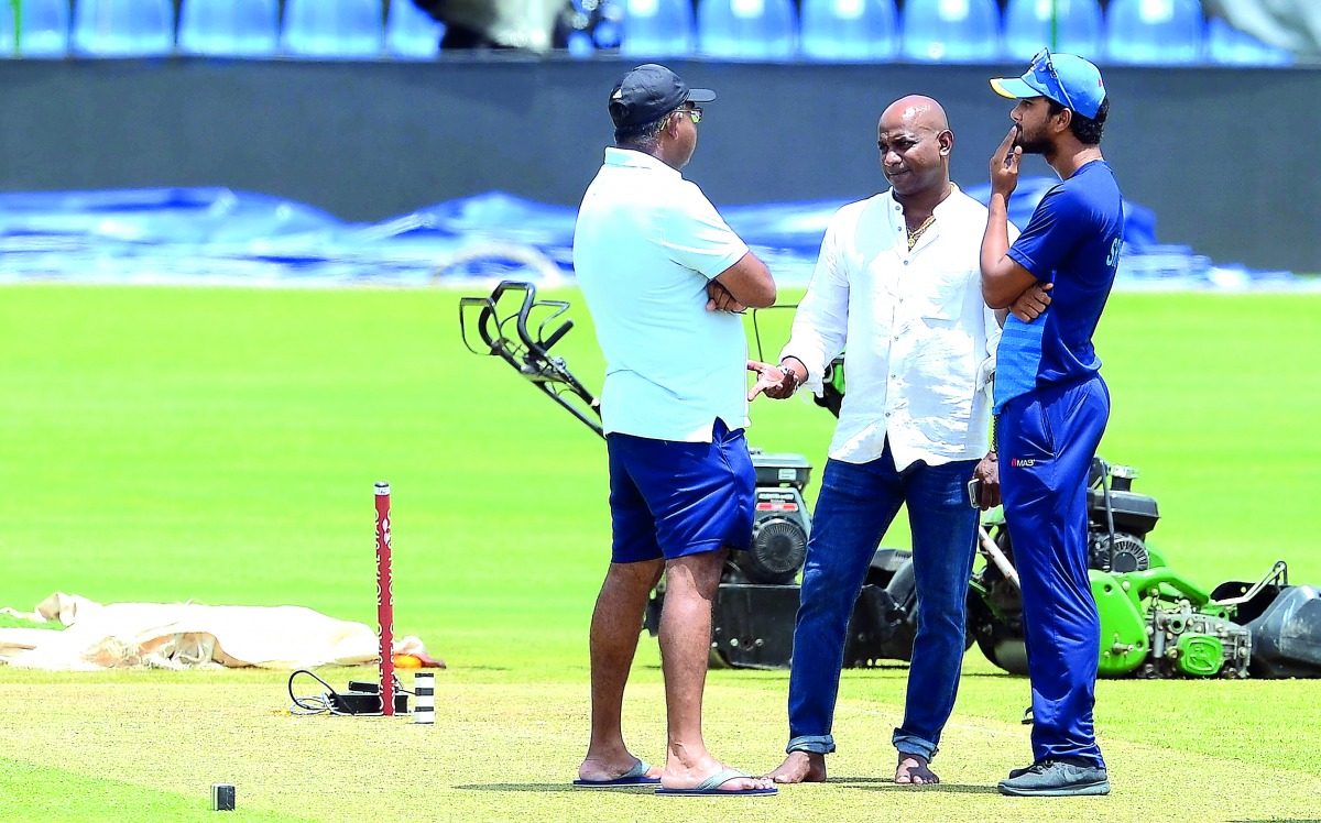 Sri Lankan chief cricket selector Sanath Jayasuriya (centre) speaks with Sri Lankan cricket team manager Asanka Gurusinghe (left) and Sri Lankan captain Dinesh Chandimal at the Pallekele International Cricket Stadium in Pallekele.