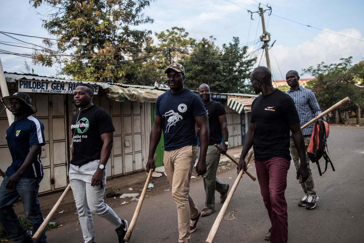 Members of a local vigilante group of bouncers and bodyguards patrol on August 12, 2017 in Kisumi, following presidential election-related violence, to protect small shops in the central business district from looters during protests.  AFP / FREDRIK LERNE