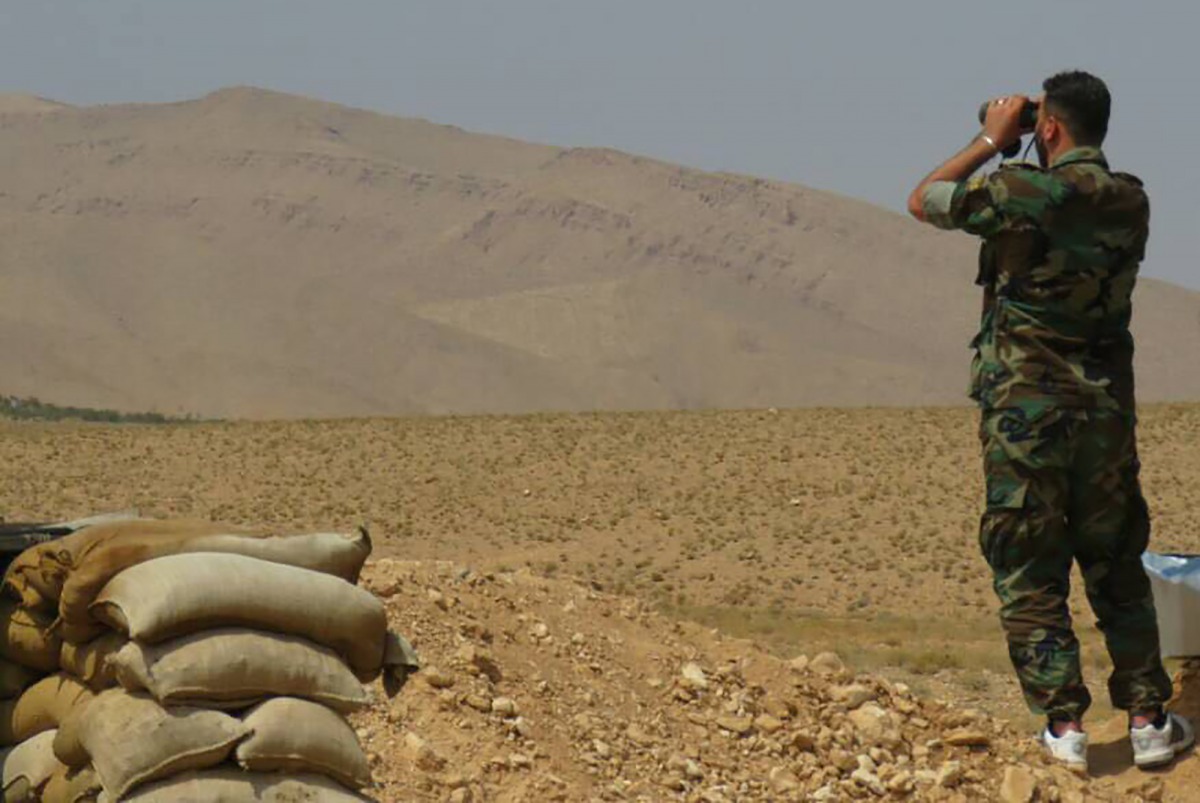 A Syrian pro-government forces uses binoculars in the western Qalamoun, on August 20, 2017, during an offensive against Islaimc State (IS) group fighters. Lebanon's battle against IS comes as the jihadist group faces assaults in both neighbouring Syria an