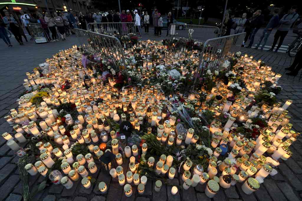 Candles and flowers have been left at the makeshift memorial for the victims of Friday's stabbings at the Turku Market Square, Finland on August 19, 2017.   AFP / Lehtikuva / Vesa Moilanen
