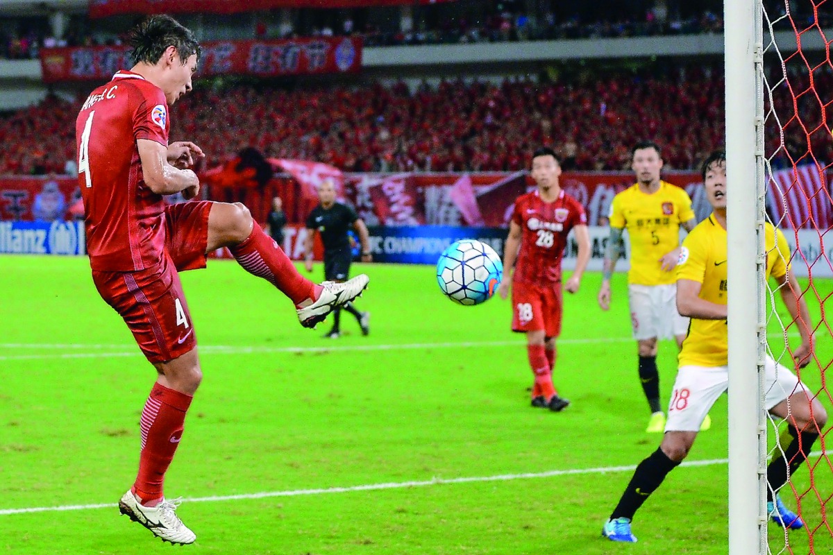 Shanghai SIPG’s Wang Shenchao (left) scores against Guangzhou Evergrande during the AFC Champions League quater-final in Shanghai, yesterday.