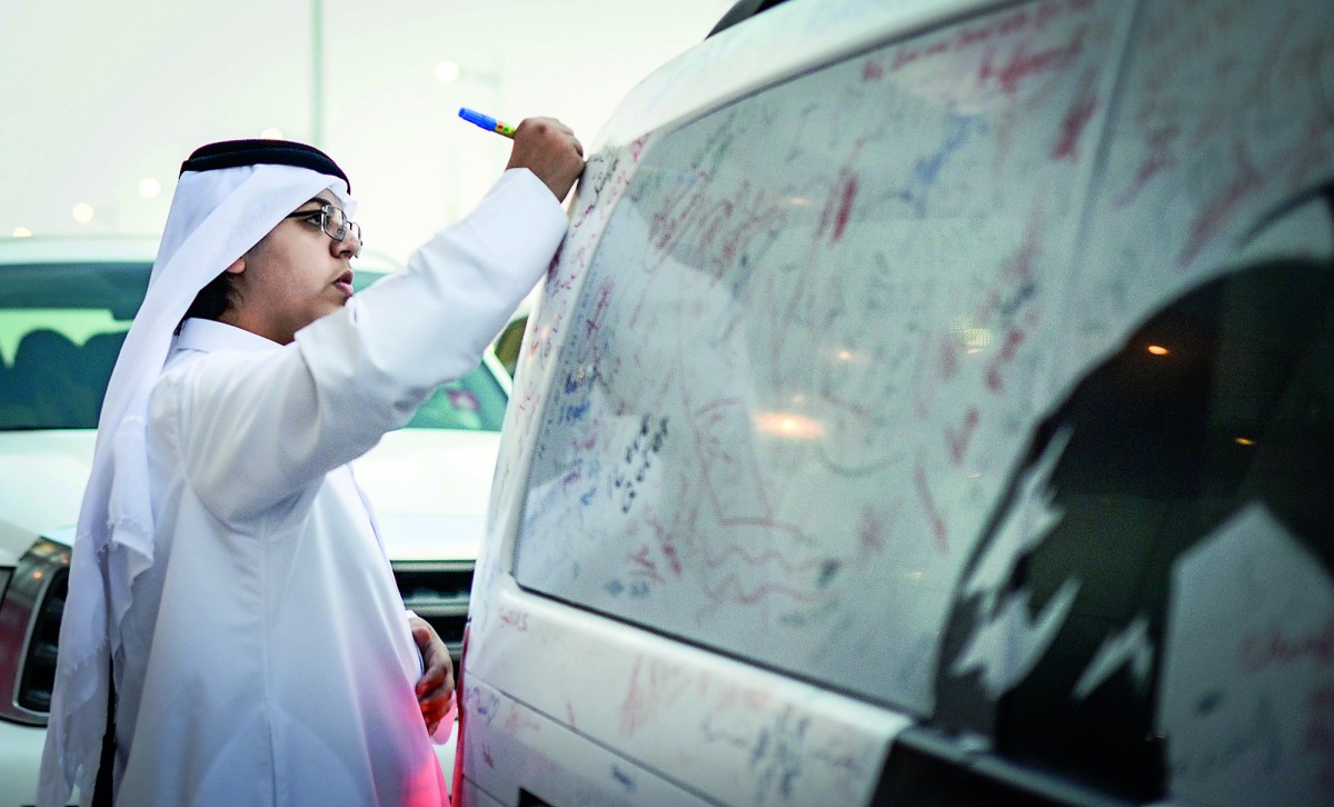 A man signing on a Mercedes-Benz vehicle as part of the national campaign ‘The Journey of Glory’ organised by Nasser Bin Khaled (NBK) Holding. 