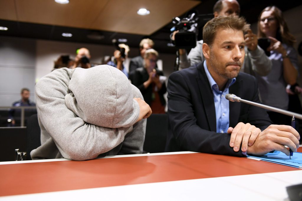 Suspect Mohamed Bakier allegedly involved in the Finnish stabbing attack covers himself next to jis lawyer Joni Brander in the Southwest Finland District Court during the remand hearing on August 22, 2017 in Turku, Finland.   AFP / Lehtikuva / Martti Kain