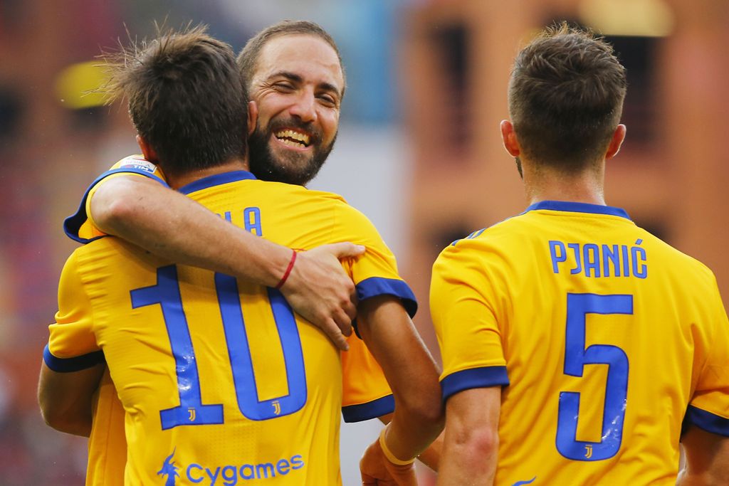 Juventus' Argentinian forward Paulo Dybala (L) celebrates with compatriot forward Gonzalo Higuain (C) after scoring during the Italian Serie A football match Genoa v Juventus at The Luigi Ferraris Stadium in Genoa on August 26, 2017. / AFP / Marco BERTORE