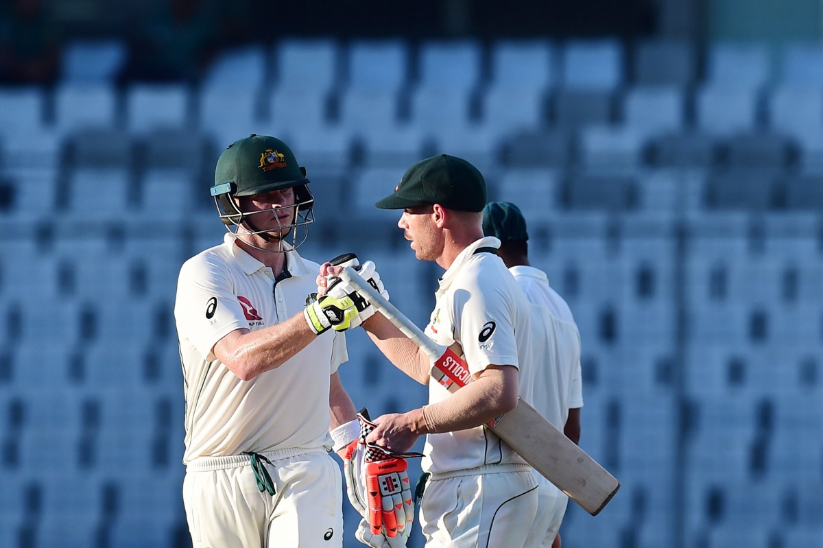Australian cricket captain Steven Smith (L) and David Warner (R)congratulate each other as they walk off the field during the third day of the first Test cricket match between Bangladesh and Australia at the Sher-e-Bangla National Cricket Stadium in Dhaka