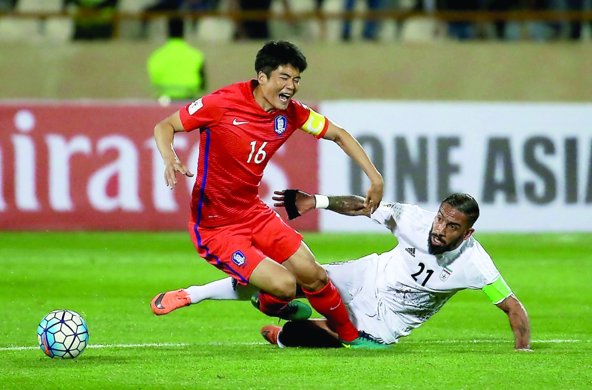 Iran’s Ashkan Dejgah (right) tackles South Korea’s Ki Sung-yueng during the 2018 World Cup qualifying football match at the Azadi Stadium in Tehran in the 2016 file picture.