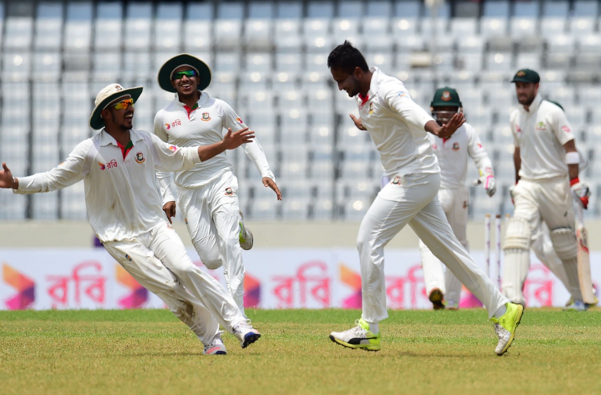 Bangladeshi cricketer Shakib Al Hasan (C) reacts after the dismissal of Australian cricketer Glenn Maxwell (R) during the fourth day of the first Test cricket match between Bangladesh and Australia at the Sher-e-Bangla National Cricket Stadium in Dhaka on