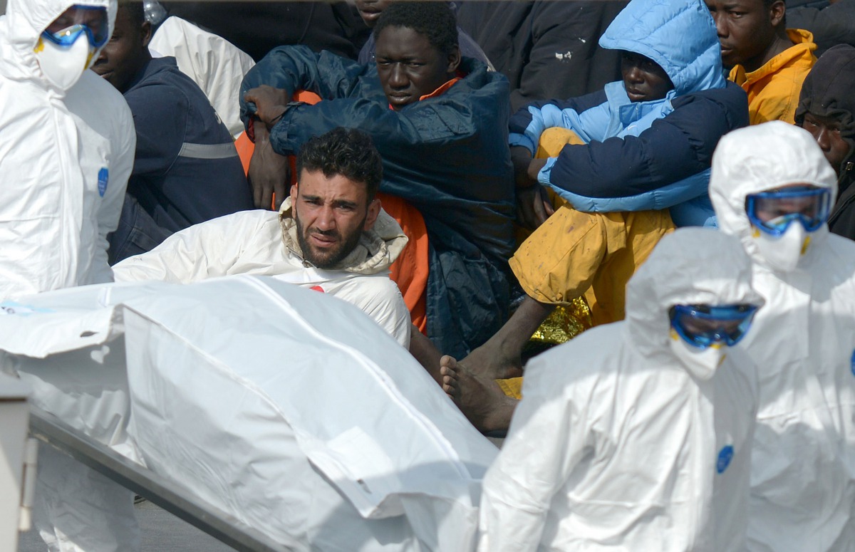 This April 20, 2015 photo shows rescuers carrying the body of a victim after coast guards followed a wrecked vessel off the coasts of Libya.  (AFP / Matthew Mirabelli) 