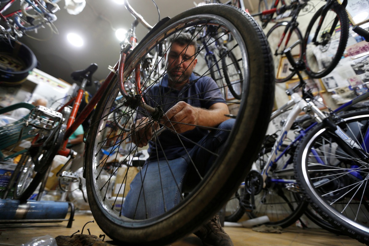 A man repairs a bike wheel at a bicycle shop in Beirut, Lebanon August 30, 2017. REUTERS/ Mohamed Azakir