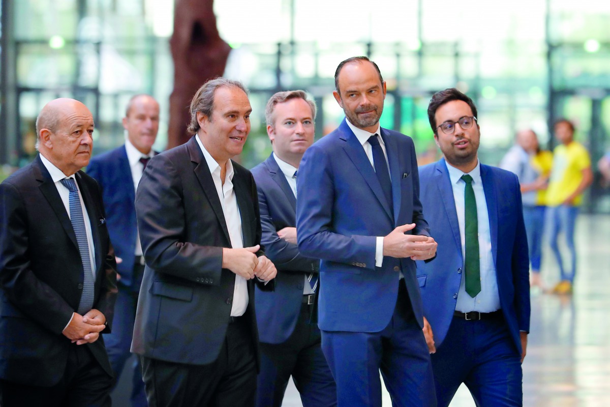Founder of French broadband Internet provider Iliad, Xavier Niel (3rd L), French Prime Minister Edouard Philippe (2nd R), French Foreign Affairs Minister Jean-Yves Le Drian (L), French Junior Foreign Affairs Minister Jean-Baptiste Lemoyne (C), French Juni