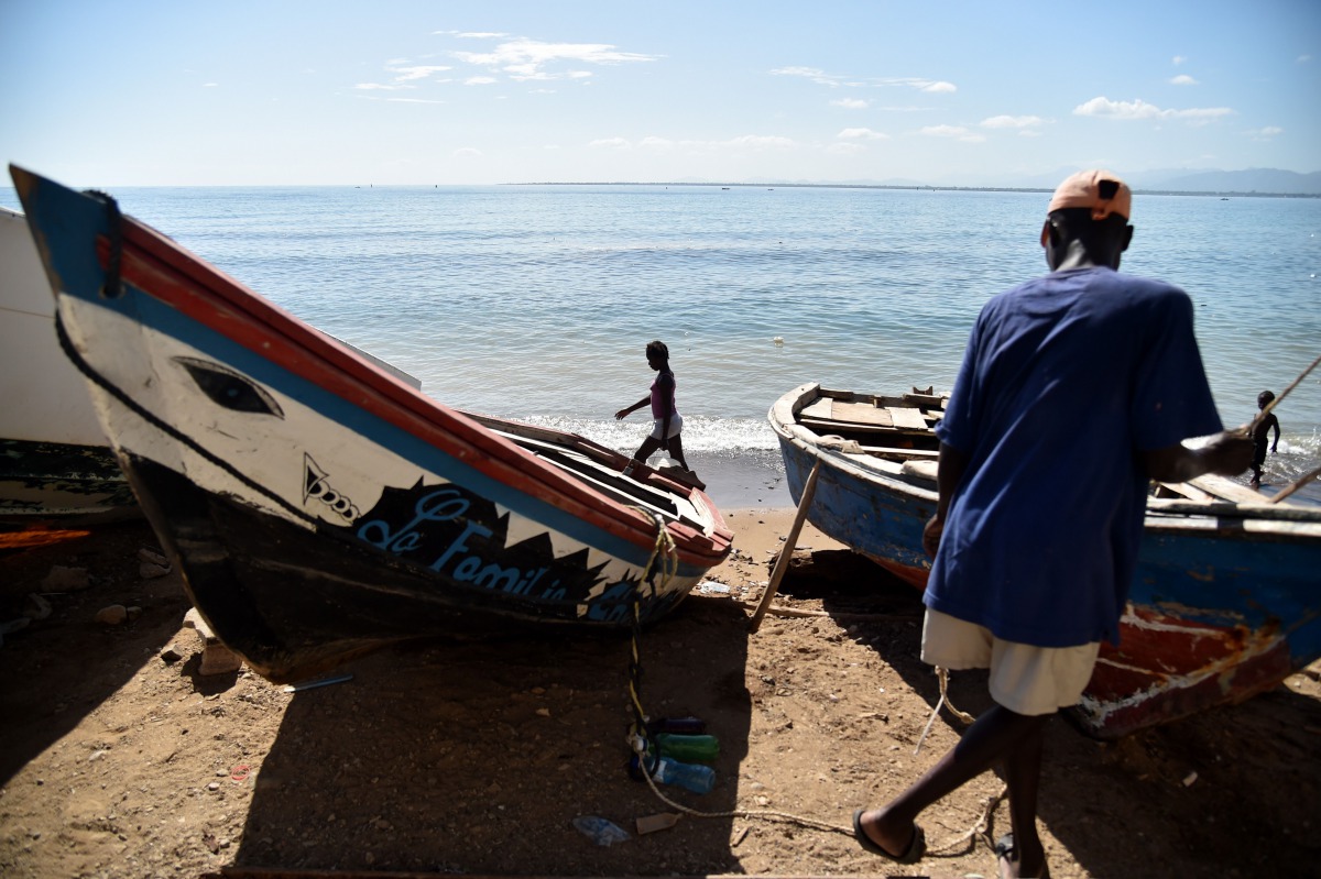 A fisherman works next to a boat in Cap-Haitien, Haiti, on September 6, 2017, 240kms north of Port-au-Prince. Some people in Cap-Haitien still do not have information on the arrival of Hurricane Irma and many others do not know what to do or where to go t