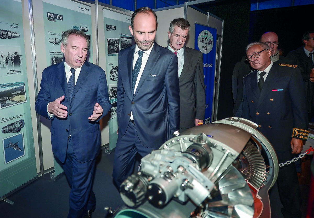 Pau mayor Francois Bayrou (C), French Prime Minister Edouard Philippe (L), French lawmaker Jean Lassalle (Rear C) and prefect of the Pyrenees Atlantiques department, Gilbert Payet (R) visit the stand of French multinational aircraft engine, rocket engine,