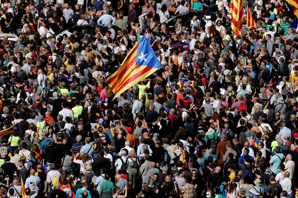 People holding 'Esteladas' (Catalan pro-independence flags) attend a protest near the Economy headquarters of Catalonia's regional government in Barcelona on September 20, 2017.   AFP / PAU BARRENA