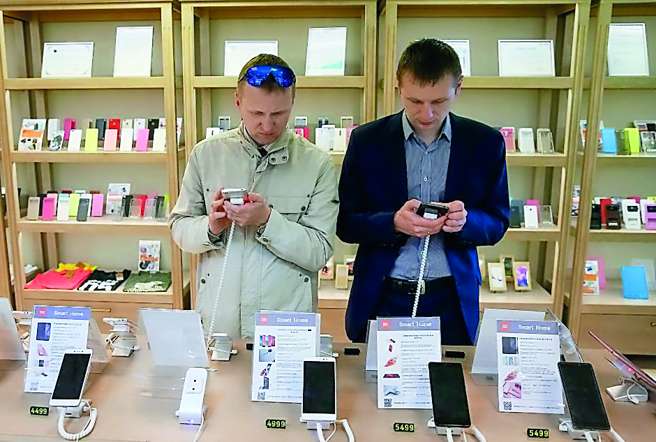 Men try out Xiaomi smartphones at the company's store in central Kiev, Ukraine May 17, 2017. REUTERS/Valentyn Ogirenko