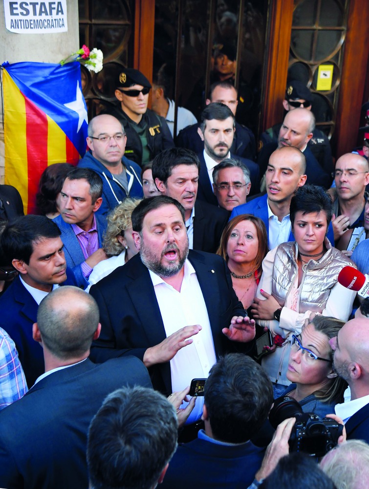 Catalan regional vice-president and chief of Economy and Finance, Oriol Junqueras talks to the people after leaving the Economy headquarters of Catalonia’s regional government during a search by Spanish Civil Guard in Barcelona, yesterday.