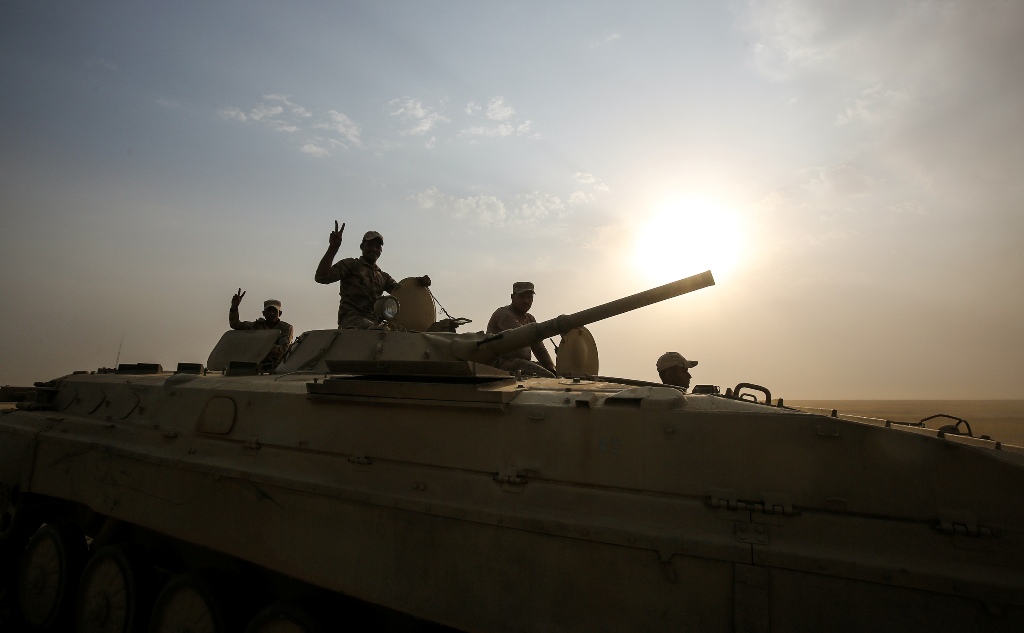 Members of the Iraqi forces flash the victory gesture as they ride in an infrantry fighting vehicle (IFV) during the advance towards the city of al-Sharqat on September 21, 2017,  AFP / AHMAD AL-RUBAYE