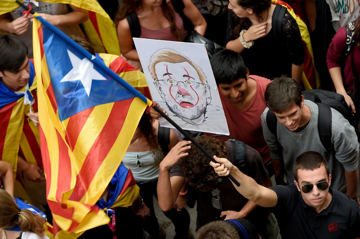 Students hold a Catalan pro-independence 'esteladas' flag and a cartoon depecting Spanish Prime Minister Mariano Rajoy gather in front of the historical headquarters of the University of Barcelona during a pro-referedum demonstration on September 22, 2017