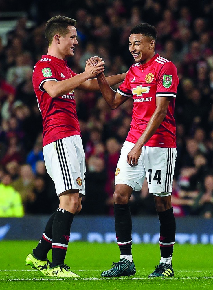 Manchester United midfielder Jesse Lingard (right) celebrates scoring his team’s third goal during the English League Cup third round match against Burton Albion at Old Trafford in Manchester on Wednesday.