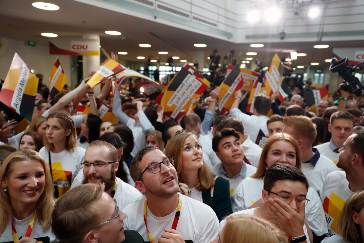 Supporters of the Christian Democratic Union (CDU) watch as exit poll results were broadcasted on public television at an election night event at the party's headquarters in Berlin during the general election on September 24, 2017. AFP / Odd Andersen