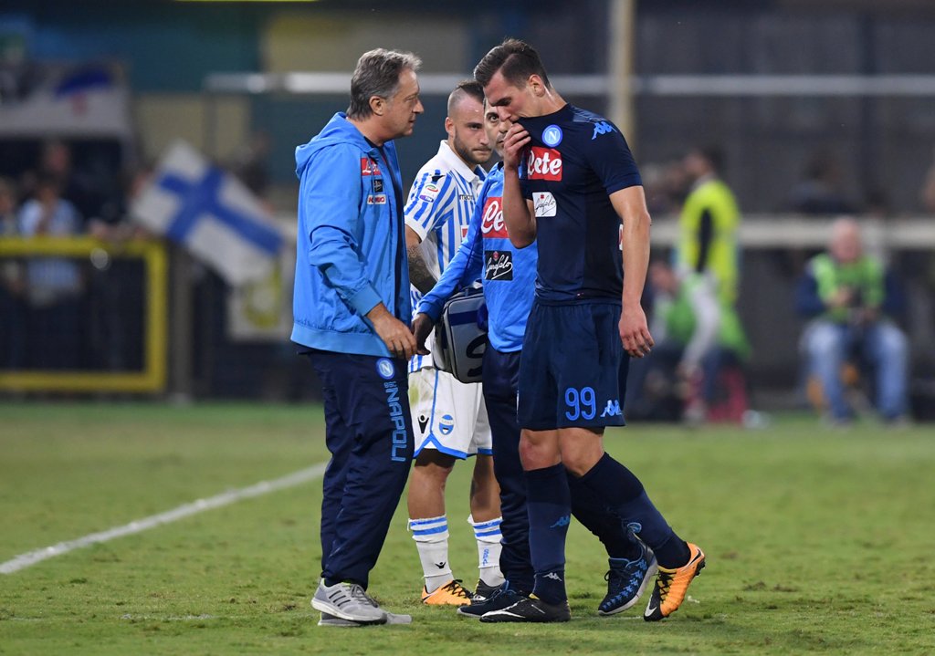 Napoli's Arkadiusz Milik walks off the pitch with medical staff after going down injured REUTERS/Alberto Lingria
