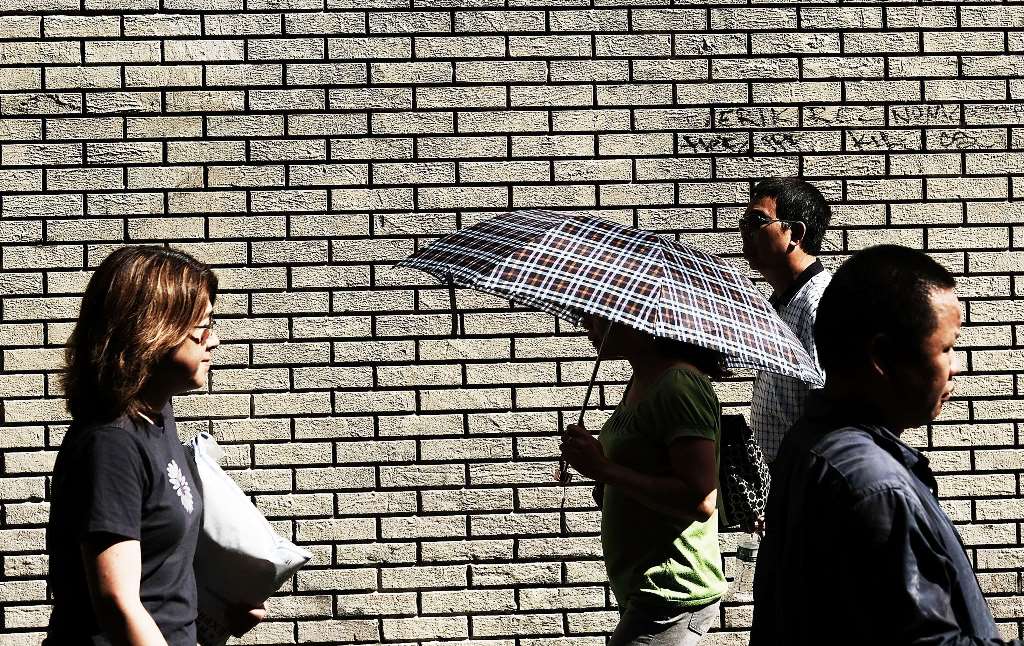 NEW YORK, NY: People walk along a Manhattan street on an unseasonably warm afternoon on September 25, 2017 in New York City. Spencer Platt/Getty Images/AFP